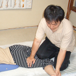股関節のストレッチを行いながら足を圧す